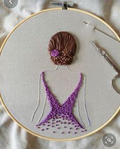 a woman's dress is being worked on with scissors and thread in the hoop