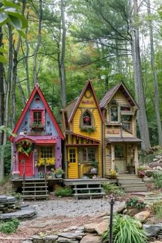 three colorful houses in the woods surrounded by trees