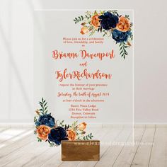 an orange and blue wedding card with flowers on it