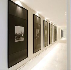 three black and white pictures hanging on the wall next to each other in a hallway