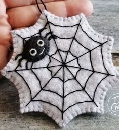 a hand holding a spider web ornament