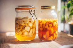 two jars filled with food sitting on top of a wooden table