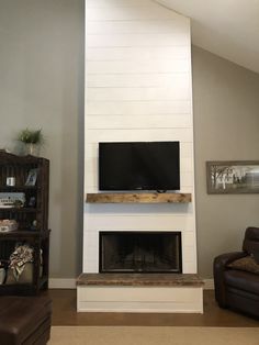 a flat screen tv mounted on top of a fireplace