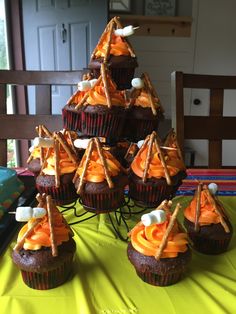 cupcakes with orange frosting and marshmallows on top are arranged in the shape of a christmas tree