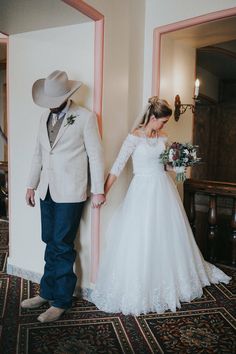 a bride and groom are standing in the hallway