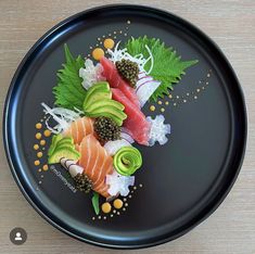 a black plate topped with different types of sushi