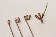 four pieces of wire sitting on top of a white surface