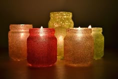 there are many different colored jars with lights in them