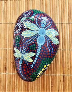 a painted rock sitting on top of a bamboo mat