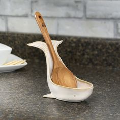 a wooden spoon in a ceramic bowl on a counter