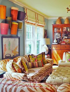 a living room filled with lots of furniture next to a fire place and a window