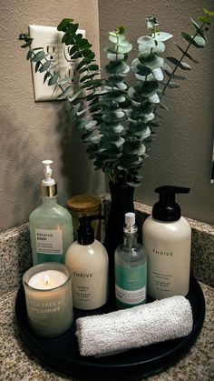 a bathroom sink with soap, lotion and candles