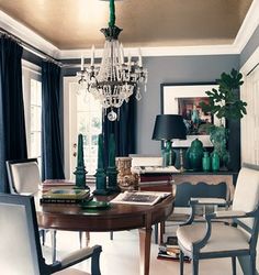 a dining room table with chairs and a chandelier hanging from it's ceiling