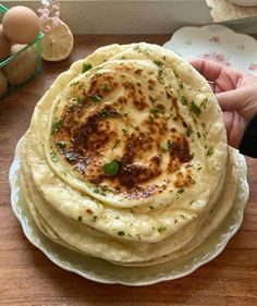 a stack of flatbreads sitting on top of a plate next to an egg