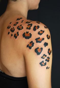 the back of a woman's shoulder with an animal print tattoo on her arm