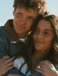 a young man and woman are posing for a photo with their arms around each other