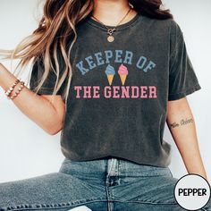 Get ready to celebrate the big reveal with our Ice Cream Keeper Of The Gender Shirt, designed to add excitement to your gender reveal party. This adorable tee is perfect for the proud auntie to wear, featuring the fun "Team Boy or Girl" theme. Let everyone know you're the keeper of the secret with this charming shirt that's sure to make your gender reveal event even more special! Comfort Colors 1717 Brand Shirt ▶Unisex Adult Sizing ▶See Our Size Chart for Proper Sizing ▶Any rolled sleeves are fo Short Sleeve Tops For Summer Gender Reveal, Summer Short Sleeve Tops For Gender Reveal, Trendy Graphic Print Tops For Gender Reveal, Fun Summer Tops For Gender Reveal, Trendy Graphic Print T-shirt For Gender Reveal, Trendy Crew Neck Tops For Gender Reveal, Trendy Short Sleeve Tops For Gender Reveal, Trendy Cotton Tops For Gender Reveal, Gender Keeper Shirt