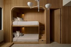 a bunk bed in a room with wooden walls and ceiling lights hanging from the ceiling