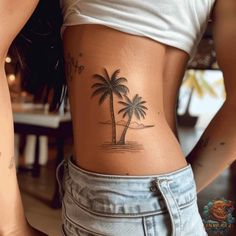 a woman with a palm tree tattoo on her lower back and the bottom part of her stomach