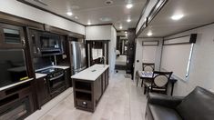 the interior of an rv with kitchen and living room