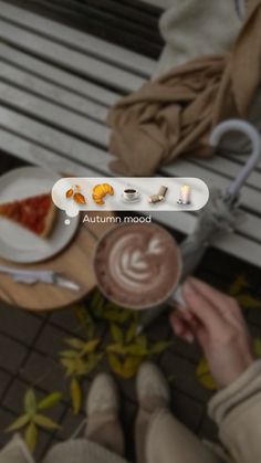 a person sitting on a bench holding a cup of coffee and looking down at the ground