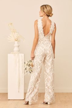 We can't help it! We're falling in love with the Lulus Enamored With You White Lace Wide-Leg Jumpsuit! Look absolutely chic on your special day with intricate, white floral lace atop a light nude knit lining that forms a deep V-neckline at the front and back with scalloped eyelash lace trim. A seamed bodice tops a high, banded waist that continues to a relaxed silhouette that ends at trendy, wide pant legs. Hidden back zipper/clasp. Fit: This garment fits true to size. Length: Floor length. Size White Lace Jumpsuit, Lace Jumper, Bridal Party Attire, Bridal Jumpsuit, Bodice Top, Wedding Jumpsuit, Jumpsuit Elegant, Traditional Wedding Dresses