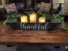 a coffee table with candles on it and a sign that says, thank you all