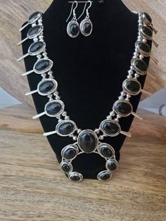 "This gorgeous sterling silver and black onyx squash blossom pendant necklace also includes the matching earrings!  The stones in this beauty are stunning and the craftsmanship is beautiful.  This black squash blossom necklace is very unique and black jewelry is timeless. This black jewelry set is truly a statement necklace! This squash blossom necklace measures 24\" long (end to end) and has a clasp closure.  The pendant on the end measures 3\" x 3\".  The matching drop earrings are about 1 1/2\" drop and make a stunning set to this gorgeous squash blossom necklace.   This set is priced well below market price and would make a lovely statement for your favorite outfit or a memorable gift for a loved one.  If you are looking for a Christmas gift, gift for mom, gift for daughter, gift for g Black Bohemian Dangle Jewelry, Bohemian Black Dangle Jewelry, Black Bohemian Jewelry With Natural Stones, Bohemian Black Jewelry With Natural Stones, Black Sterling Silver Jewelry, Unique Nickel Free Black Necklaces, Unique Nickel-free Black Necklaces, Bohemian Onyx Jewelry For Jewelry Making, Southwestern Black Sterling Silver Jewelry