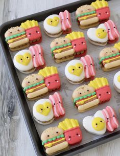 decorated cookies in the shape of hamburgers and hotdogs on a baking sheet