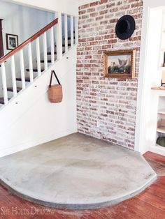 a brick wall in the corner of a room with a basket hanging on it's side