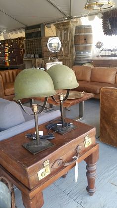 a living room filled with lots of furniture and lamps on top of wooden tables in front of couches