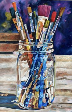 a jar filled with lots of paint brushes