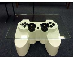 a glass table with a white controller on it and two black controllers in the middle