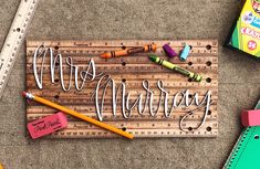 a wooden sign that says mr and mrs on it with crayons next to it