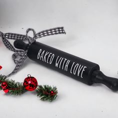 a black tube with baked with love written on it next to christmas decorations and baubles