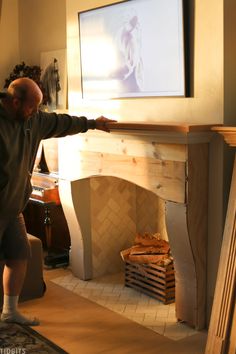 a man standing in front of a fireplace with a flat screen tv on the wall