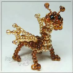 a beaded dog figurine is shown in gold and brown colors on a white background