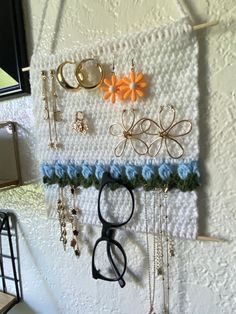 there is a wall hanging with many different items on it, including scissors and necklaces