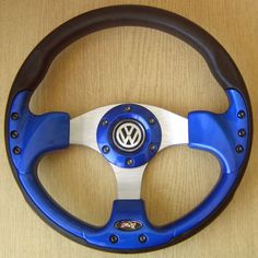 the steering wheel is blue and white with black spokes on it, along with a wooden table