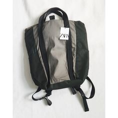 a back pack sitting on top of a white sheet covered floor with a tag attached to it