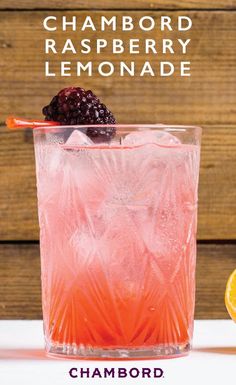 a glass filled with lemonade and blackberries on top of a table