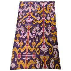 a purple and yellow table cloth with an ornate design on the front, in different colors