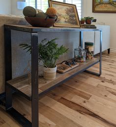 a living room filled with furniture and a potted plant on top of a wooden shelf