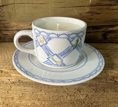 a cup and saucer sitting on top of a wooden table