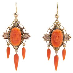 This pair of 18 karat gold and coral drop earrings are High Victorian in terms of their age and appearance and are a beautiful example of 19th century craftsmanship. The pair each centre on an oval cameo of a woman carved from natural coral which has been framed in an elaborate 18 karat gold setting that has been oxidised in areas to bring out the brightness of the gold. To the bottom of the cameo medallions hang three carved coral drops which sway with the movement of the wearer. To affix to th Coral Drop Earrings, Victorian Earrings, Shepherds Hook, Natural Coral, Gold Set, 19th Century, Coral, Jewelry Earrings, Yellow Gold