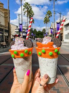 two ice cream sundaes with sprinkles and candy on the top