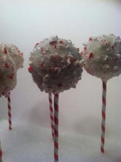 three lollipops with sprinkles and candy canes on them