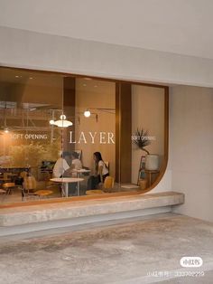 a store front window with people sitting at tables