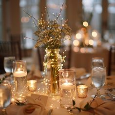 a table with candles and flowers on it in a room filled with tables cloths