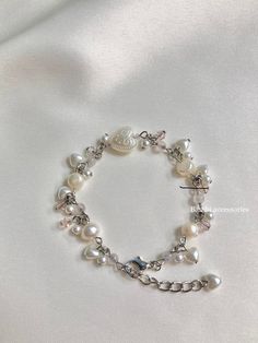 A sweet and elegant accessory that adds a touch of princess charm to any outfit! This beaded pink & creamy bracelet features dangly beads for a playful and stylish look. With a touch of freshwater pearls and glass beads crafted with care, it's the perfect piece of princess jewelry. ꔫ 𝓭𝓮𝓵𝓲𝓿𝓮𝓻𝔂 ꔫﾟ UK Orders - shipped with 1st class royal mail - which usually takes 1-2 business days to arrive International orders- all sent with standard shipping which takes around 1-2 weeks These orders do Elegant Pink Heart Beaded Bracelets, Elegant Pink Heart-shaped Beaded Bracelets, Elegant White Pearl Bracelet With Heart Charm, Feminine Pearl Bracelets With Pearl Charm, Wedding Pearl Bracelet With Heart Beads, Elegant Pink Beaded Bracelet With Heart Charm, Wedding Pearl Heart Bracelet, Pearl Heart Bracelet For Wedding, Wedding Heart-shaped Pearl Bracelet